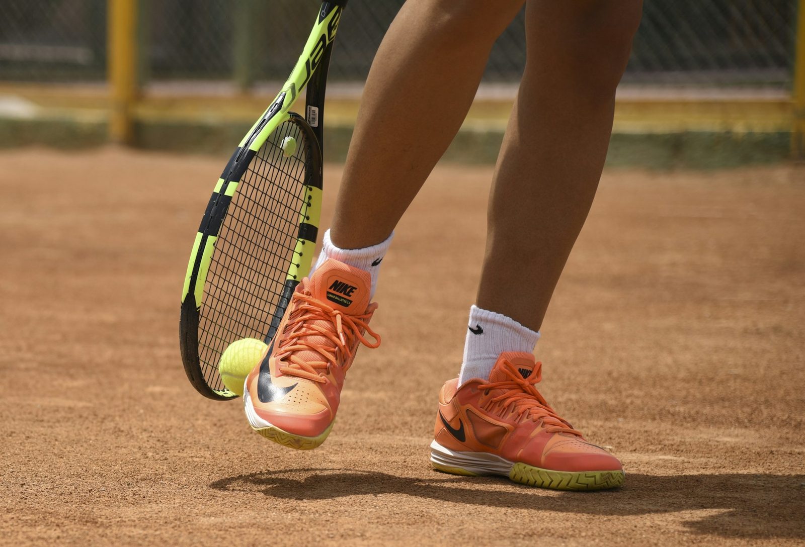 A player in court shoes holding a tennis racquet