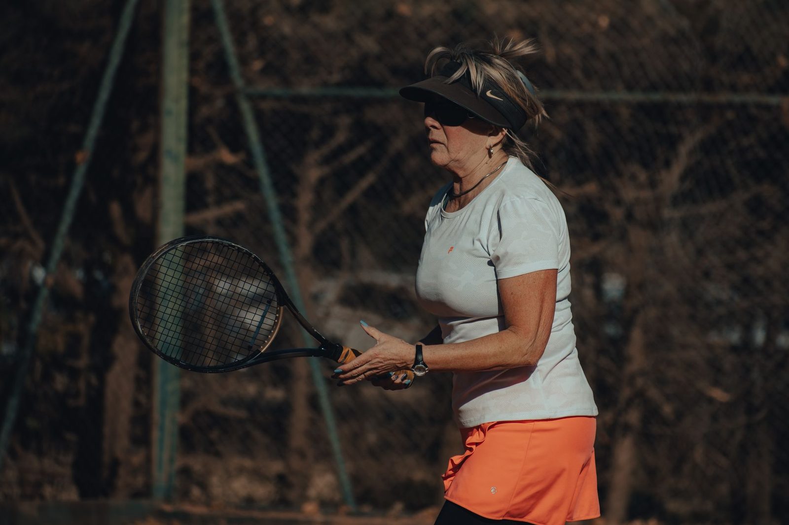 Senior player in action on a tennis court during a session