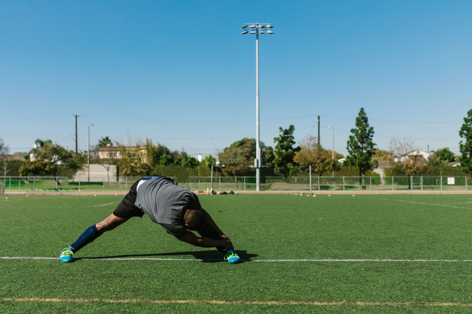 Athlete stretching outdoors on a sunny day before training