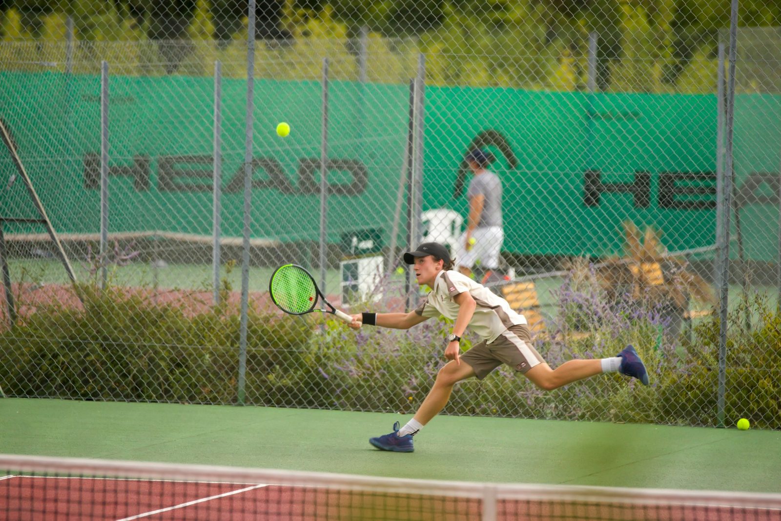 A man running forward to hit a tennis ball
