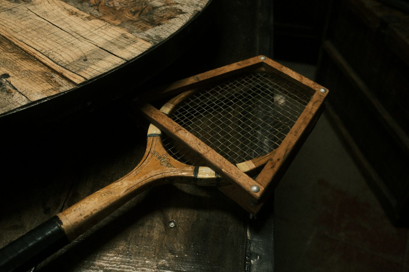 A tennis racquet resting on a wooden table