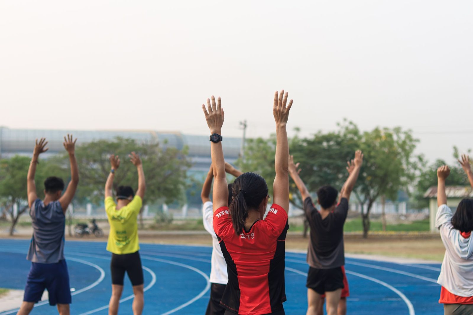 A group of adults exercising together on an outdoor track