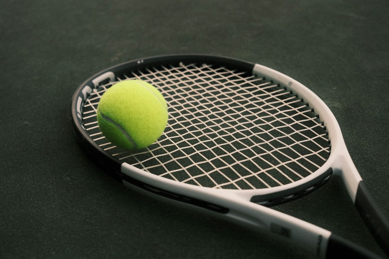 A tennis racquet and ball on a court