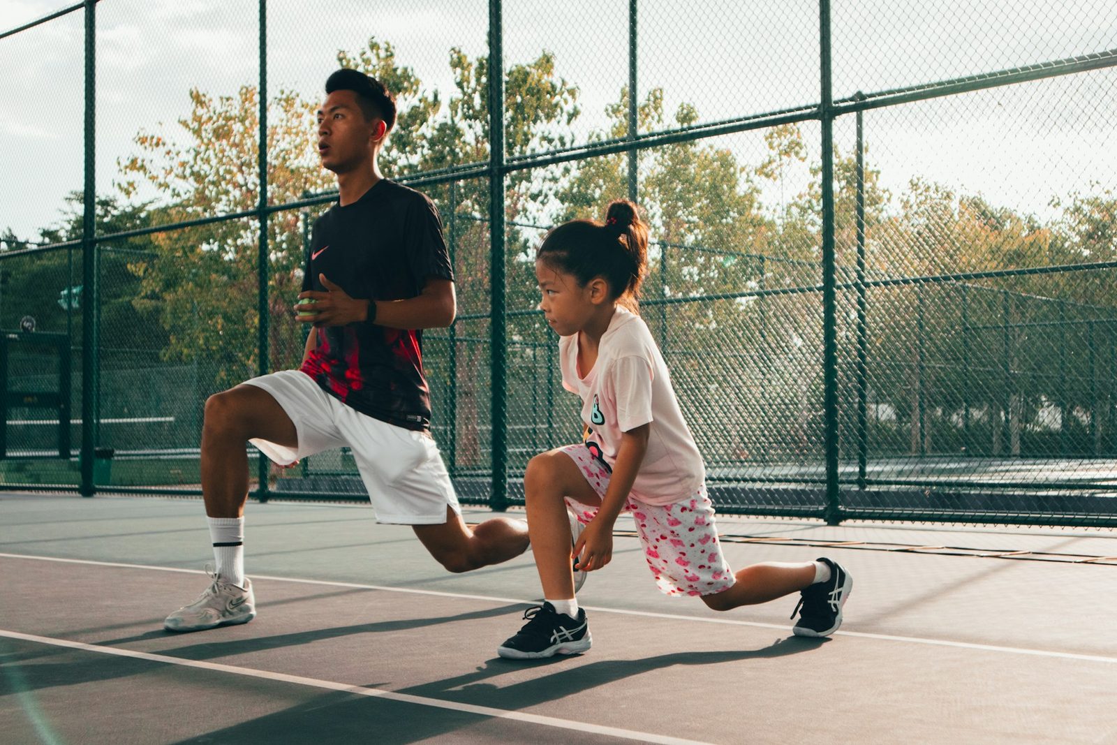 Two people playing tennis together on a court