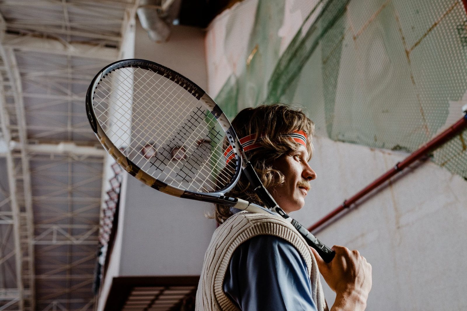 A focused tennis player holding a racquet indoors