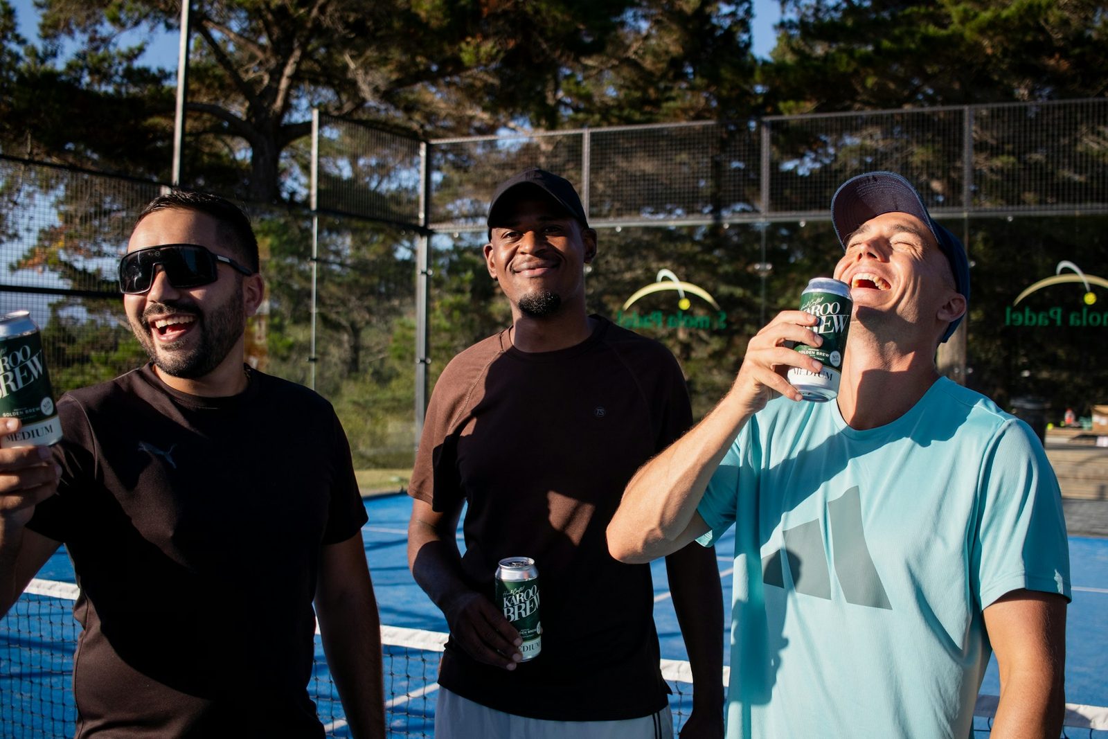 Three people standing together on a tennis court