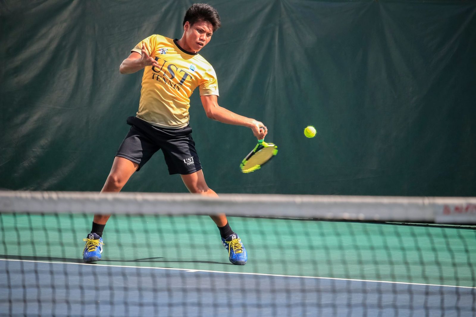 Male player hitting a forehand during an outdoor tennis match