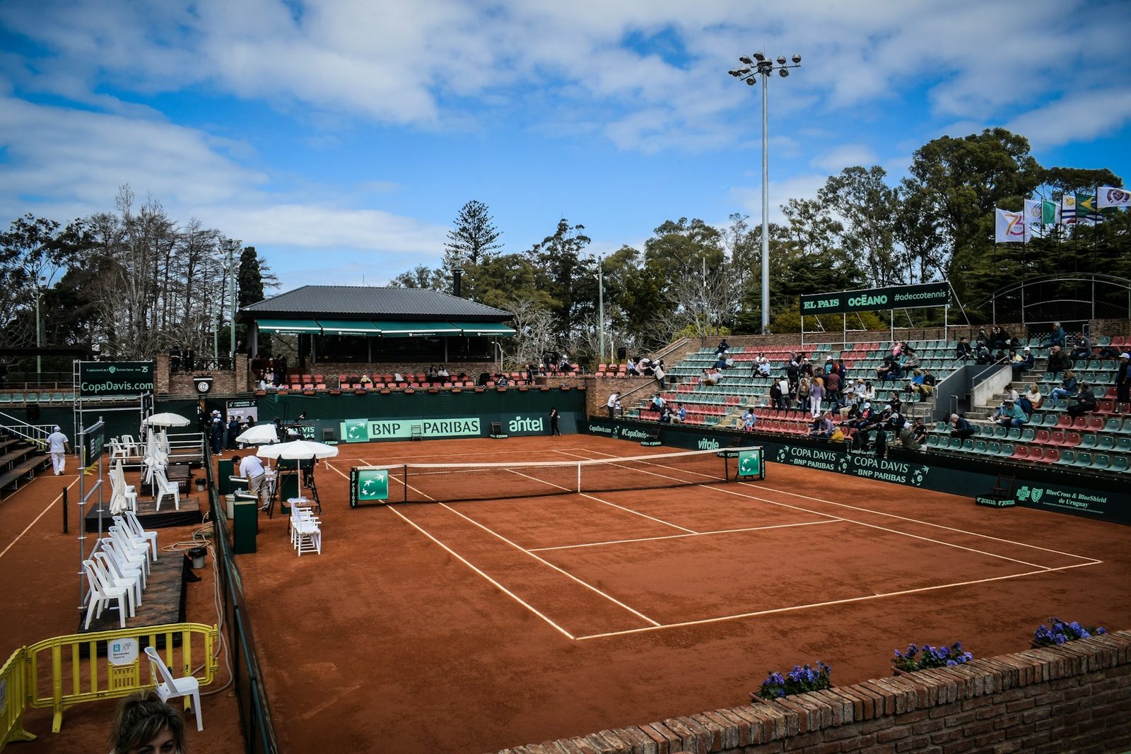 A tennis court with a crowd watching a match
