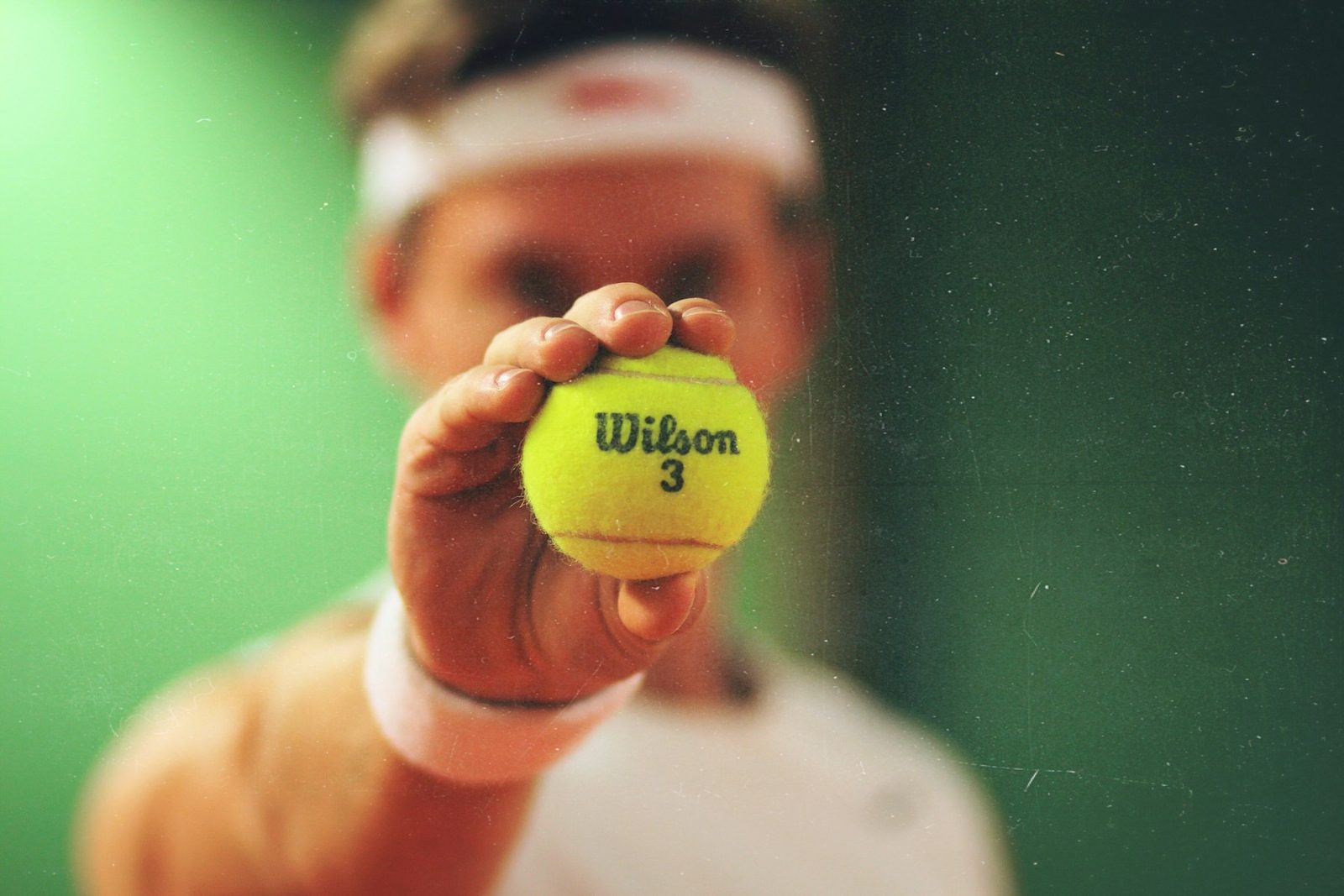 Player holding a green tennis ball and racquet