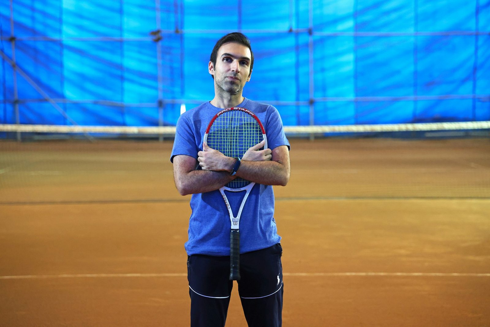 Player standing on court holding a racquet after finishing a session