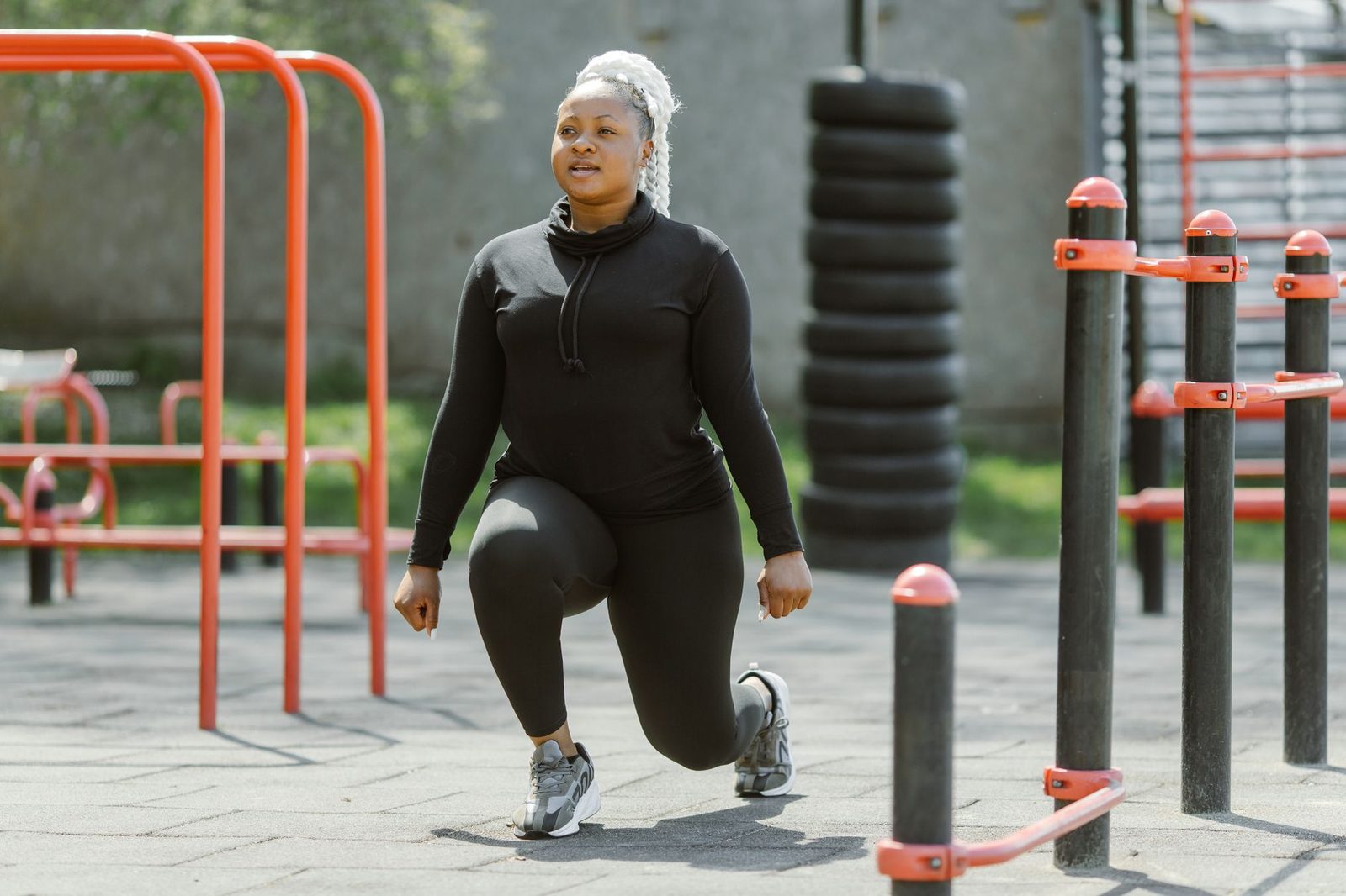 A woman performing lunges at an outdoor gym
