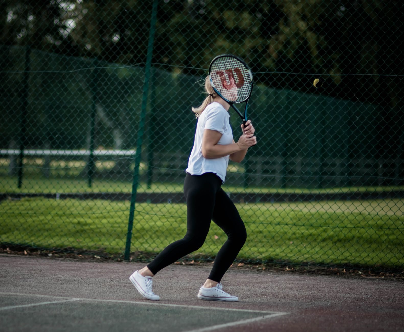 Woman poised with her racquet ready to play a return shot