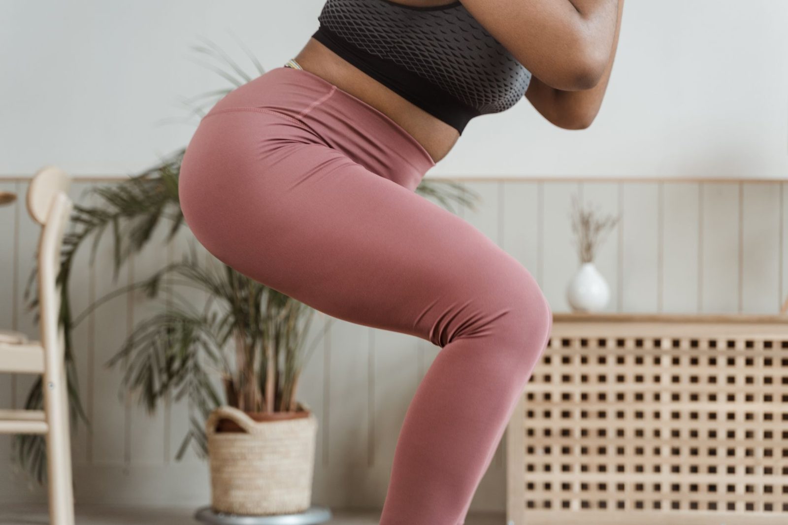 Close view of a woman performing a squat indoors