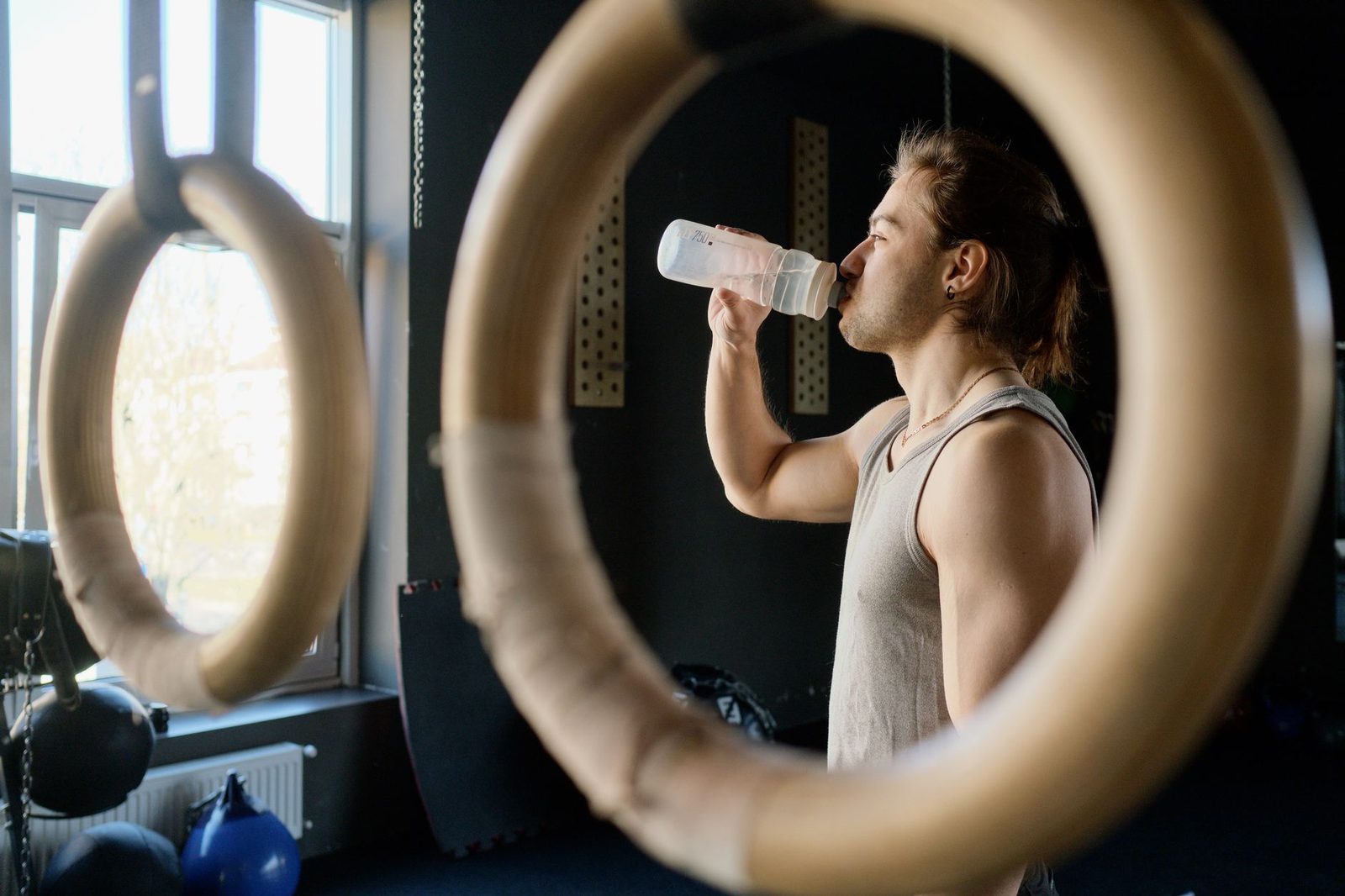 Athletic man drinking water in the gym after a workout