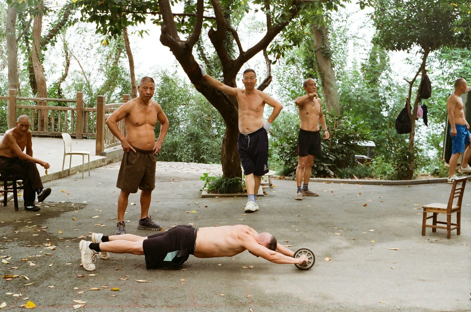 Men exercising outdoors with a roller wheel