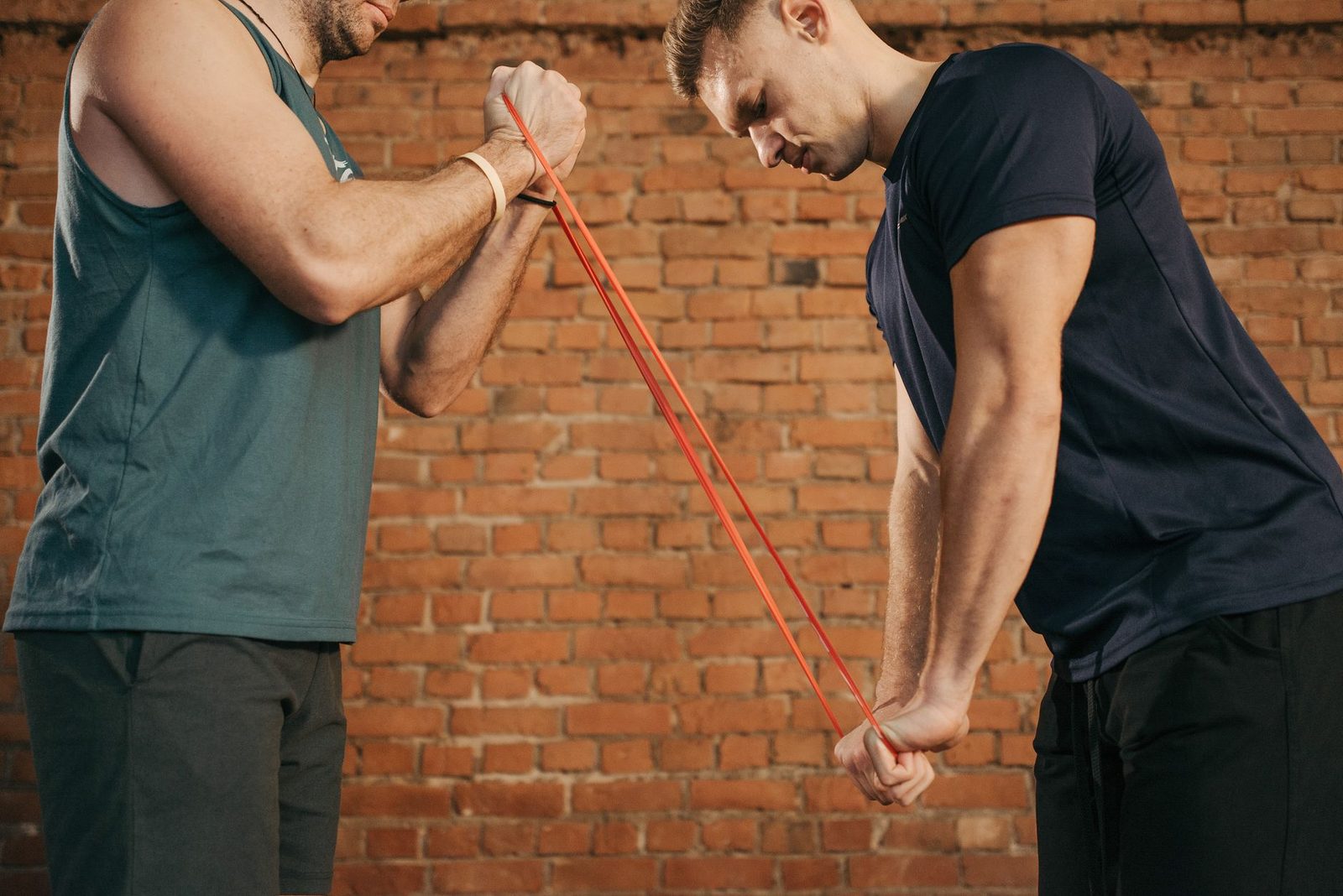 Two people exercising with a resistance band in a gym