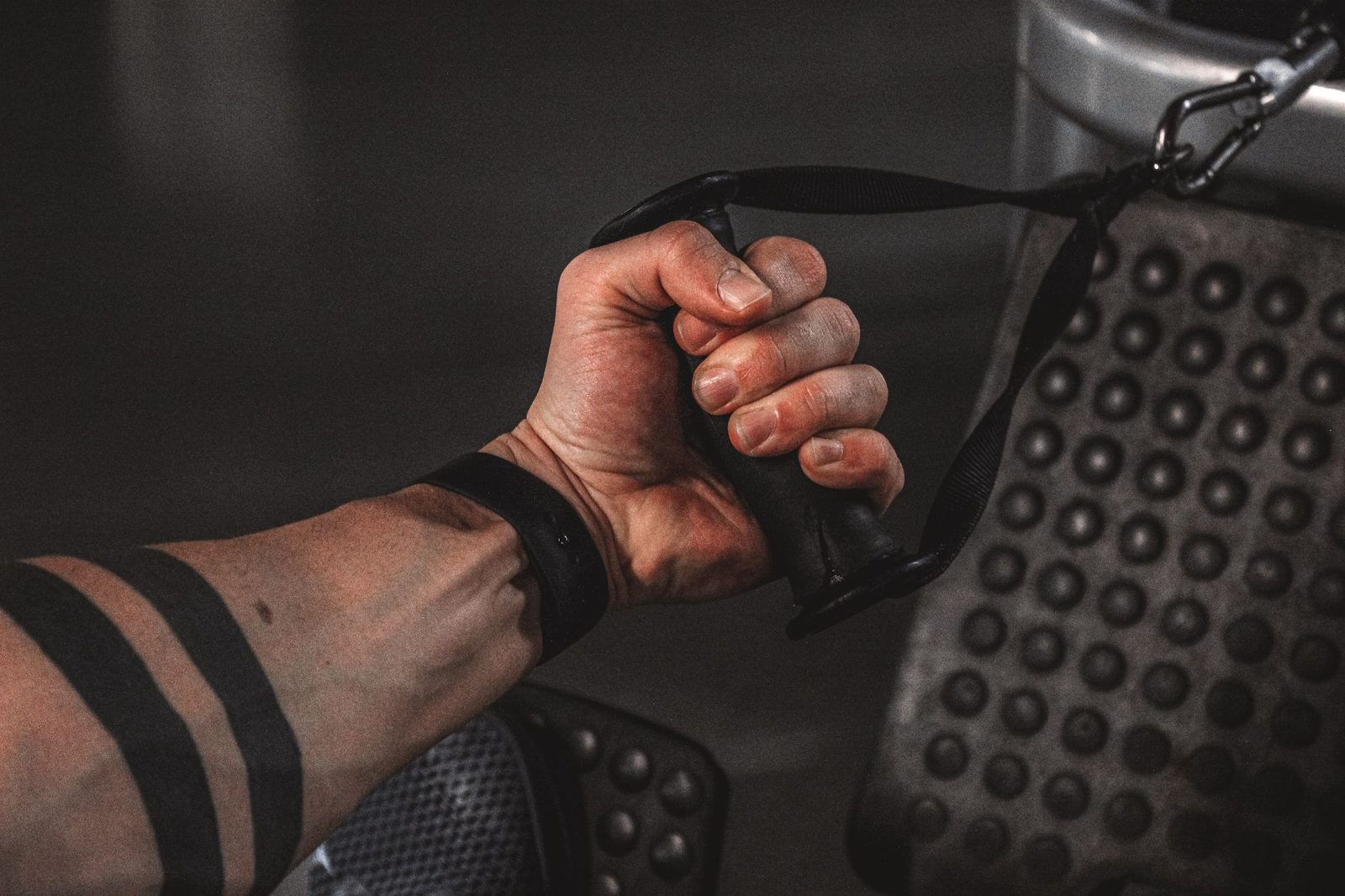 Close view of a hand gripping a gym cable during a strength exercise