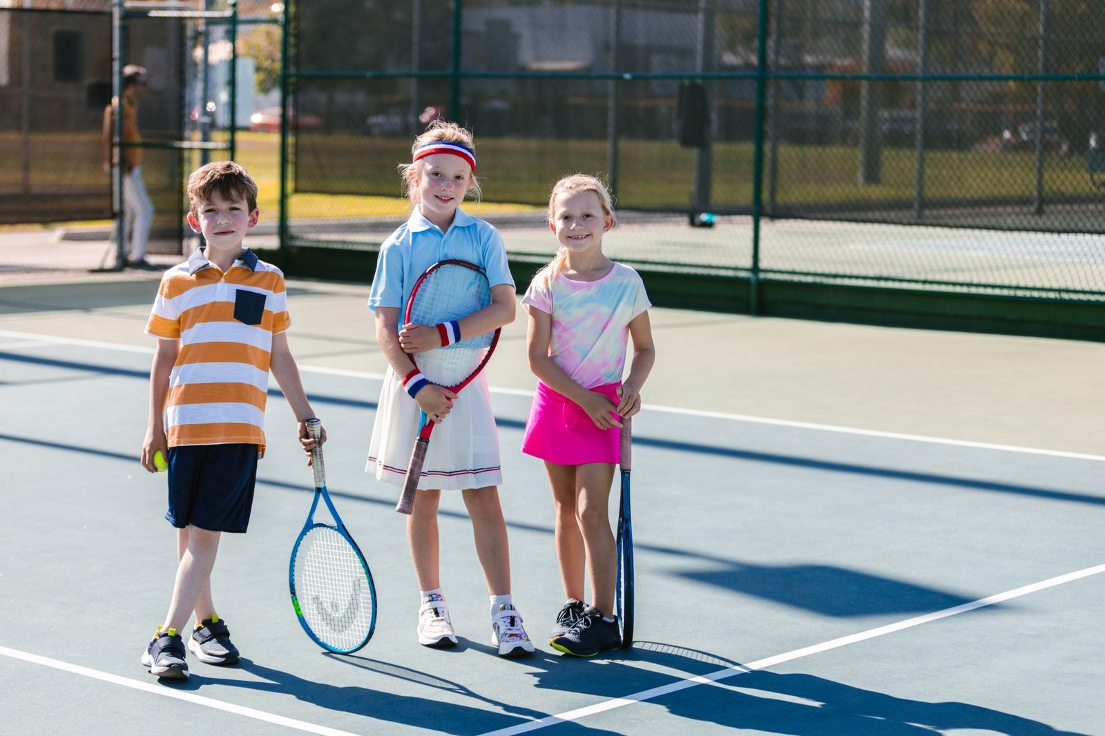 A group playing tennis outdoors together on a sunny day