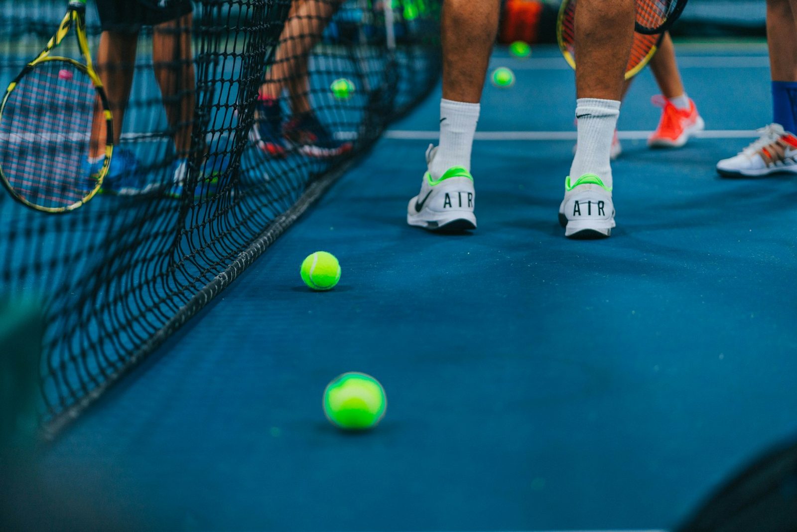 Player in tennis shoes standing on a green tennis court