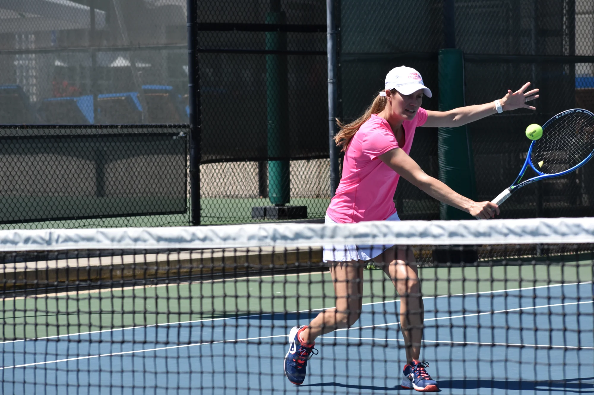 Claire Carter hitting a backhand volley at the net