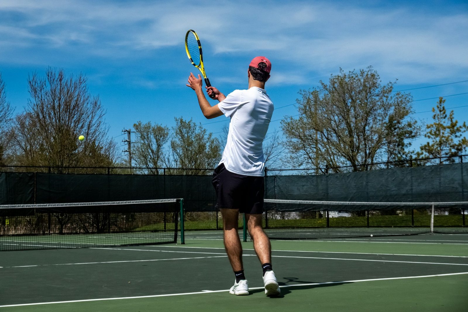 Player standing on a tennis court holding a racquet between repetitions