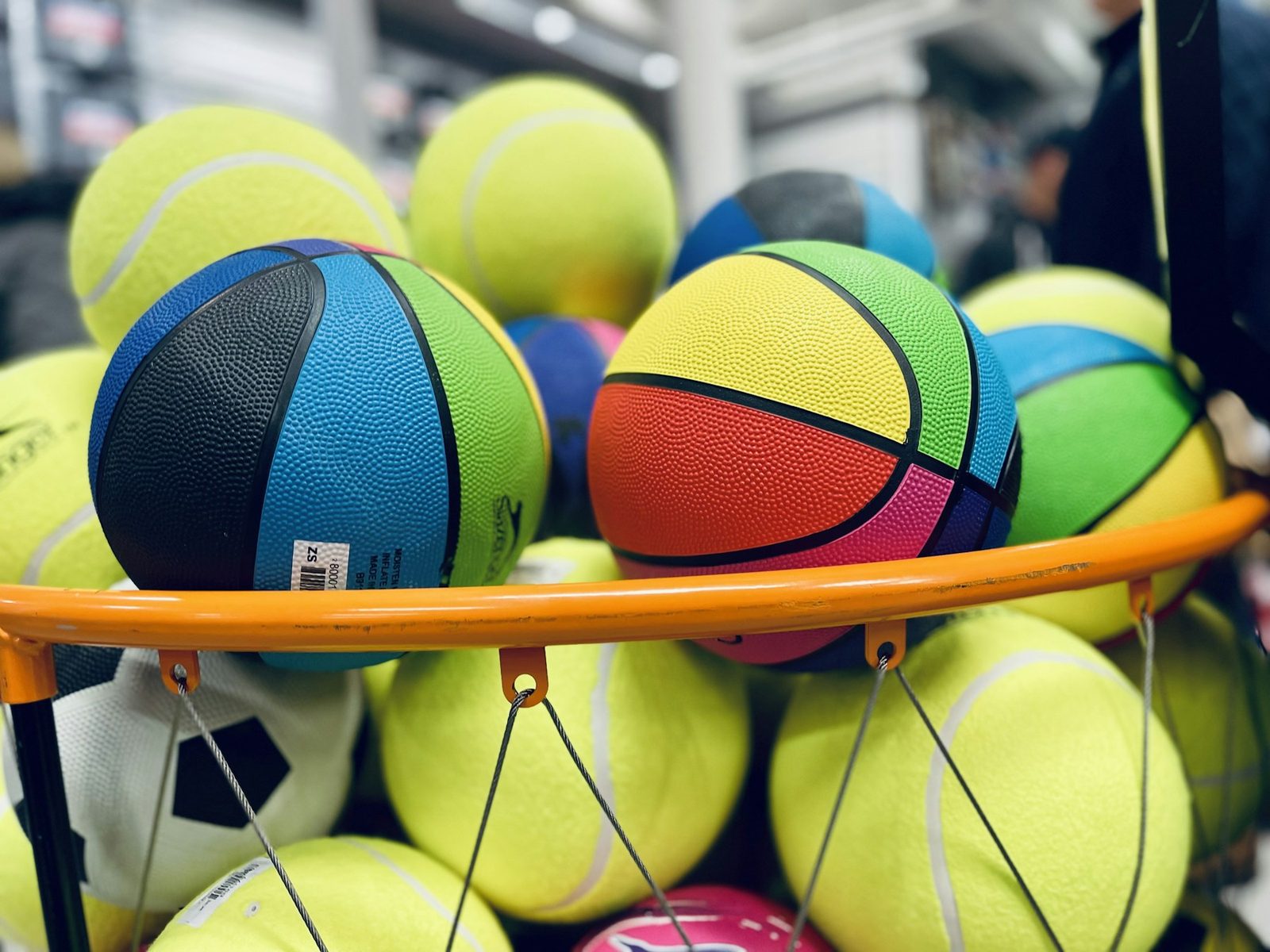 A pile of tennis balls sitting on a rack