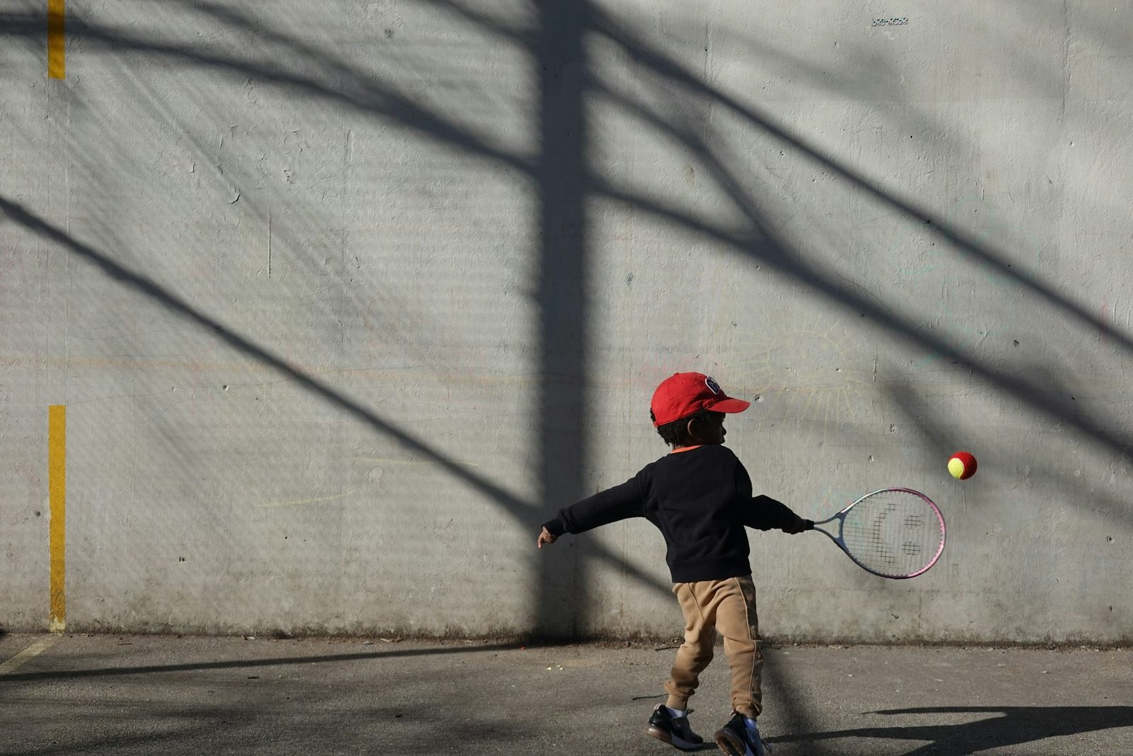 A young boy hitting a tennis ball with a racquet during a lesson