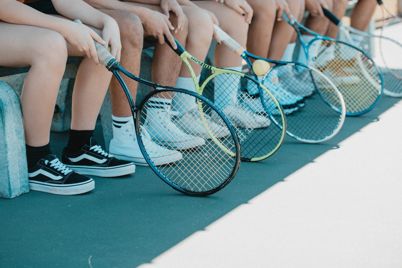 Young player in tennis shoes holding a racquet during a training session