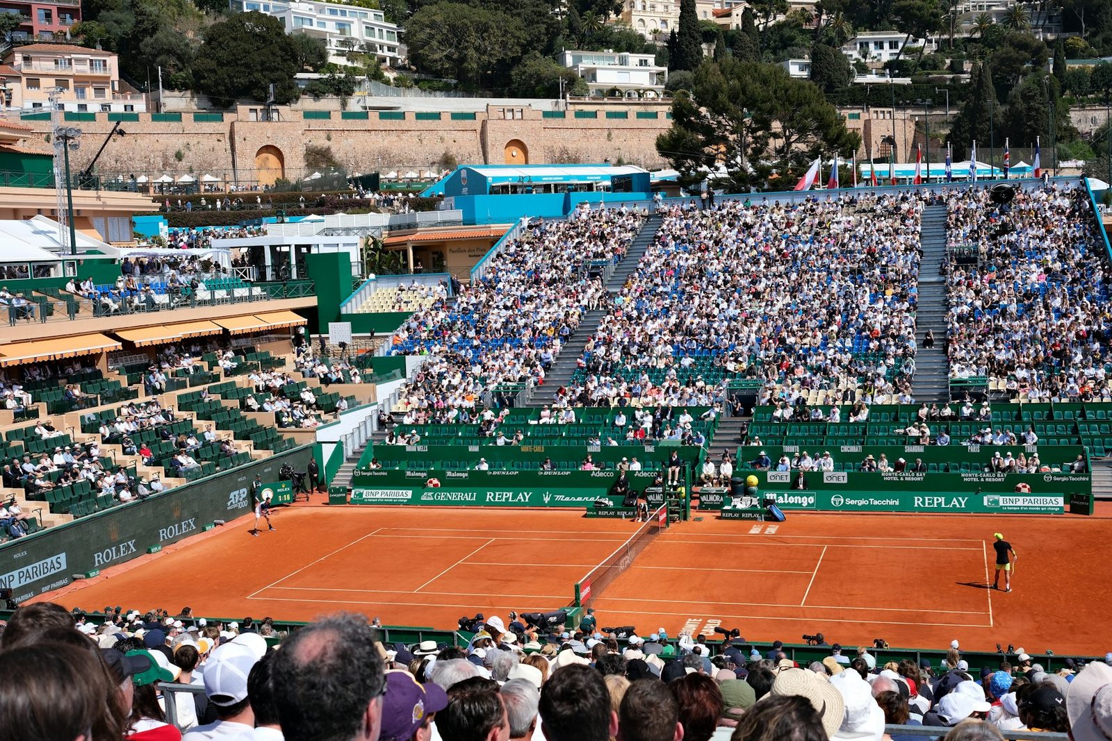 A tennis match being played in front of a crowded stadium
