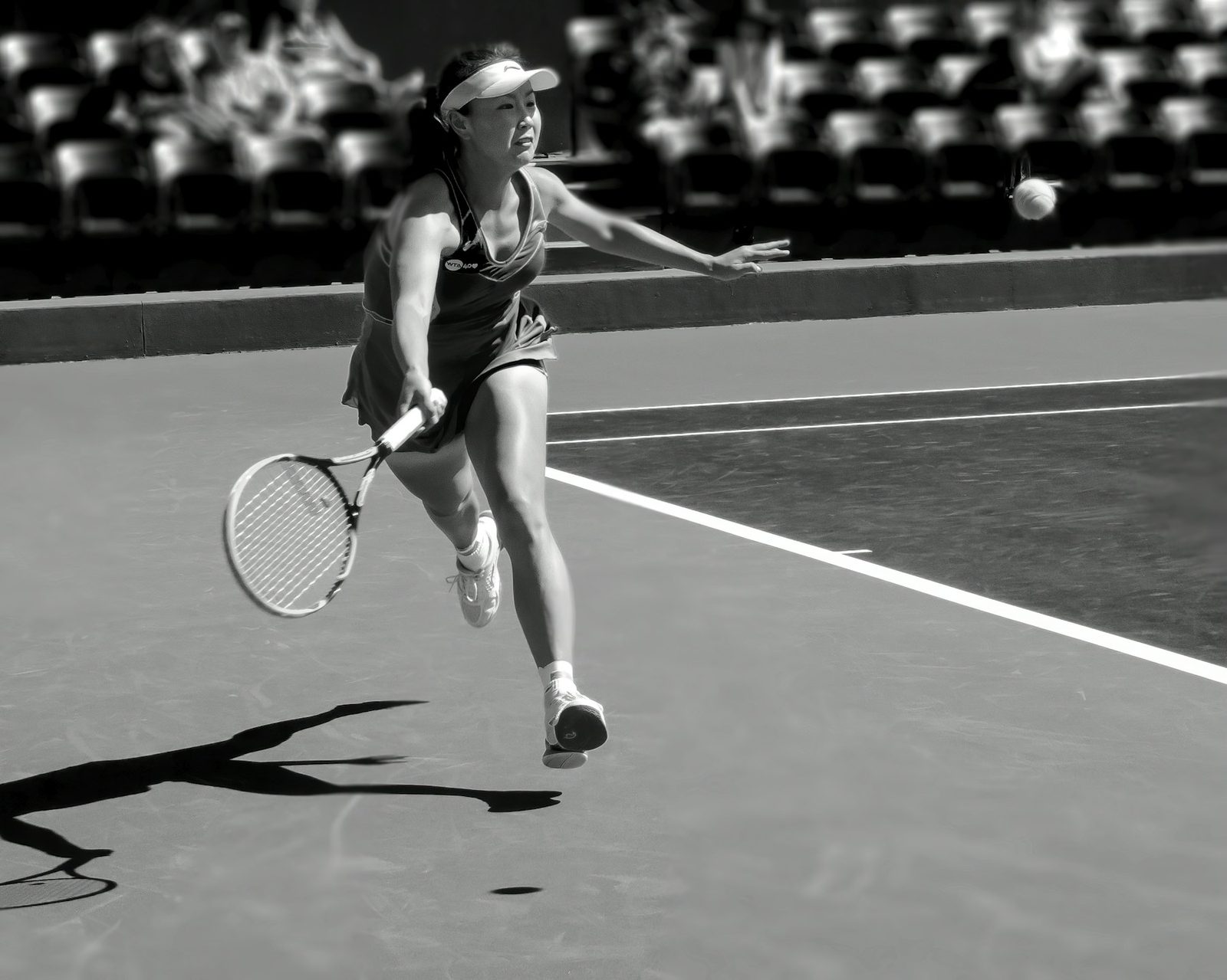 Black and white photograph of a tennis player in the middle of a rally