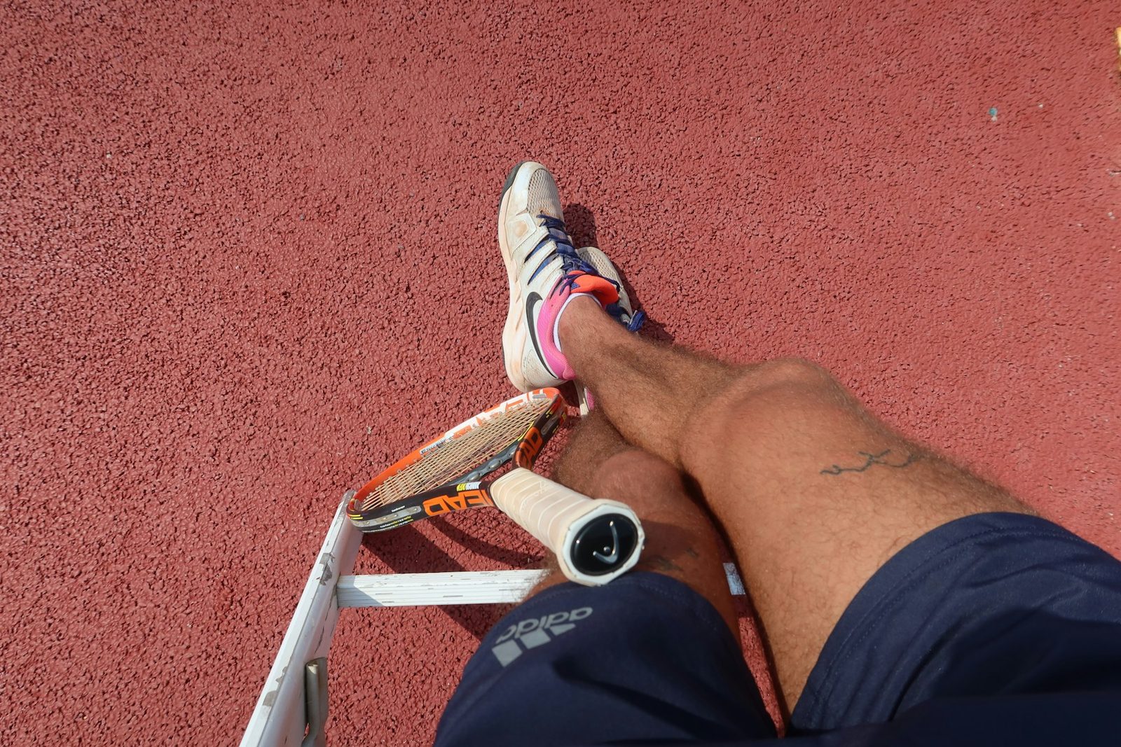 A tennis player resting on the court between points
