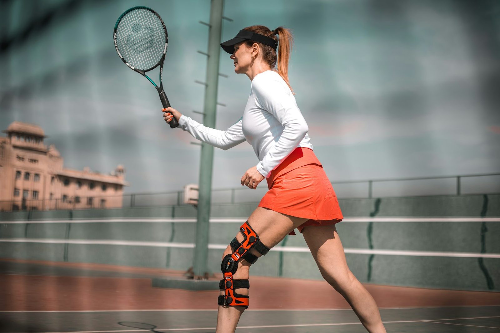 A woman with a tennis racquet on a tennis court