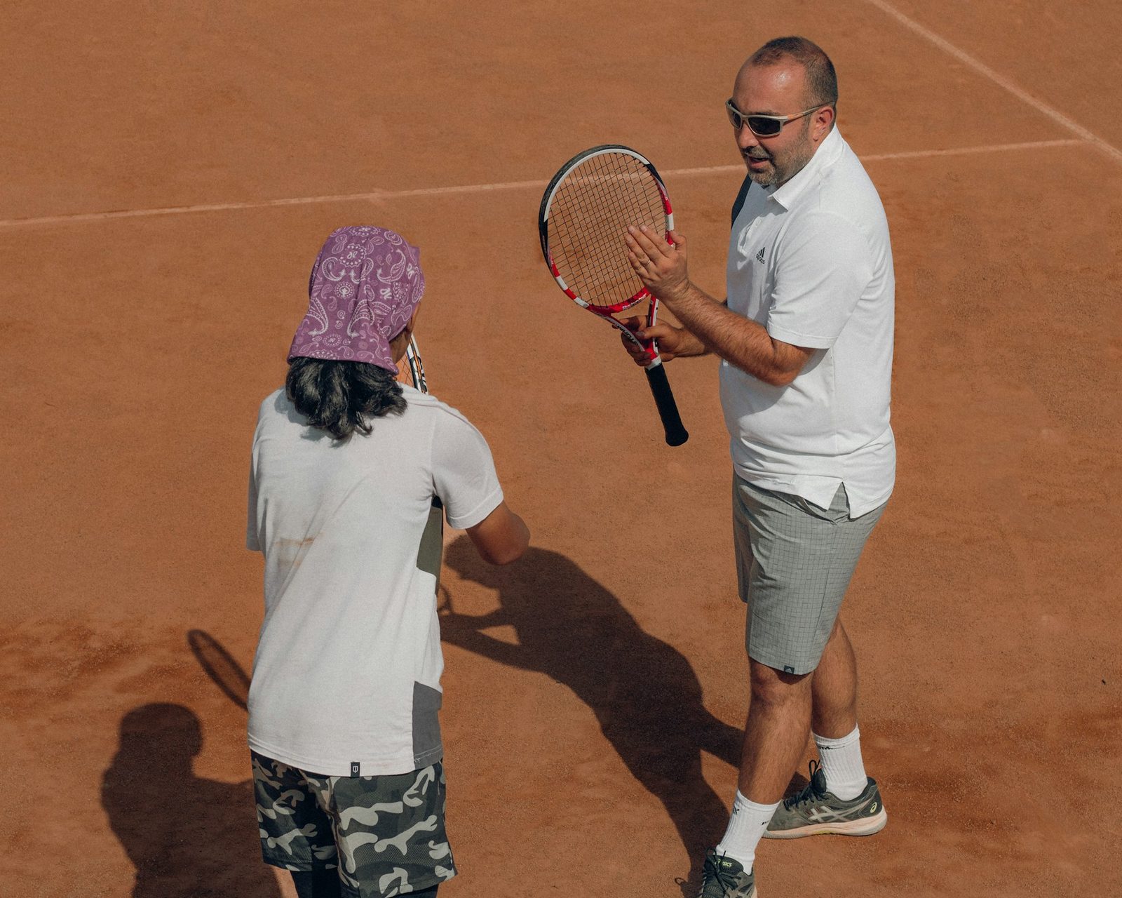 A man and a woman holding tennis racquets