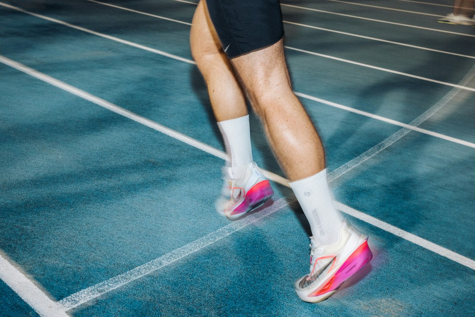 Runner's legs mid-stride on an outdoor track