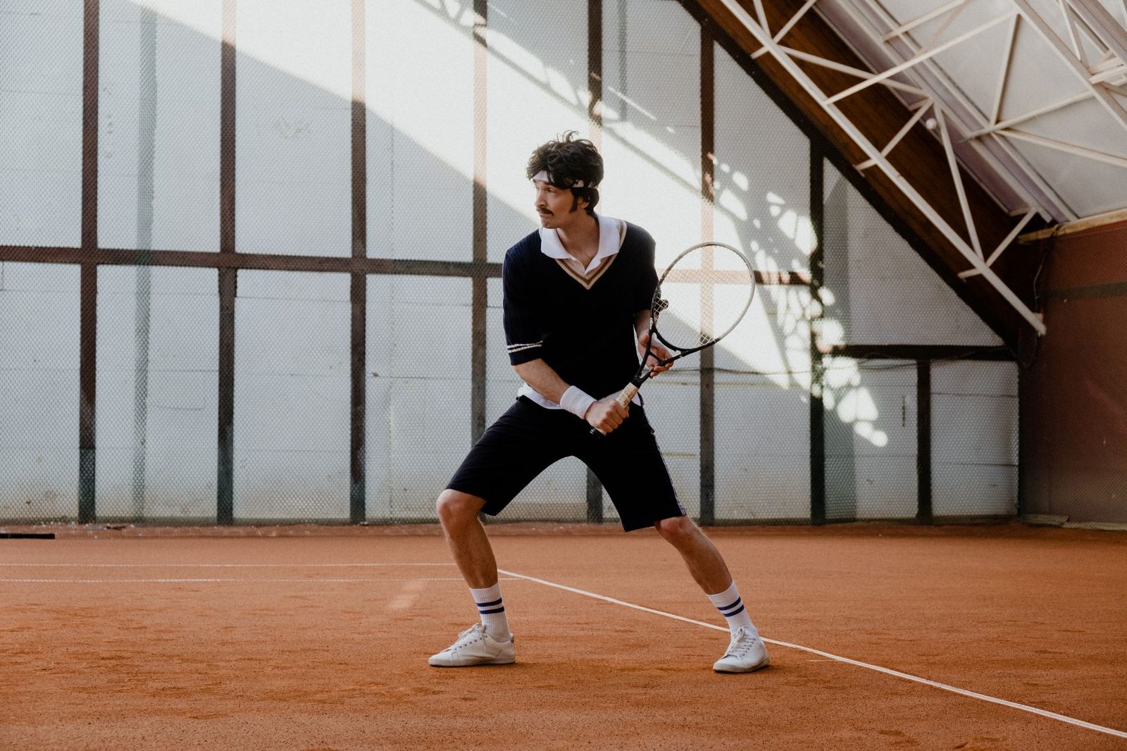 Player in a ready position during a rally on an indoor clay court