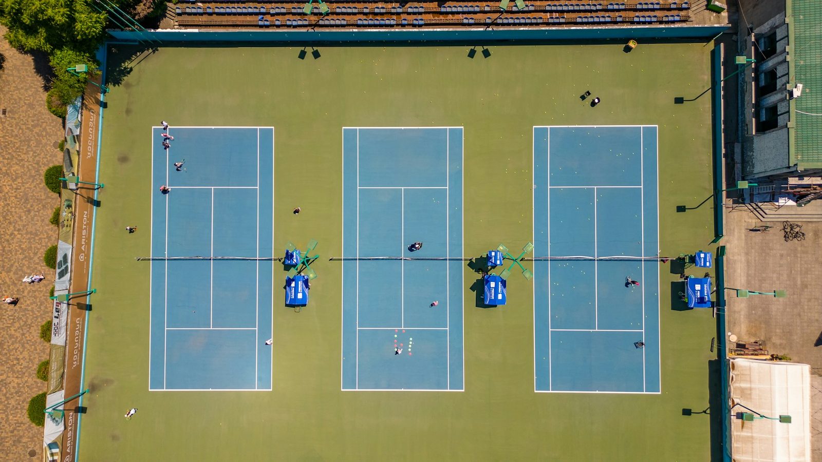Aerial view of three blue outdoor tennis courts side by side