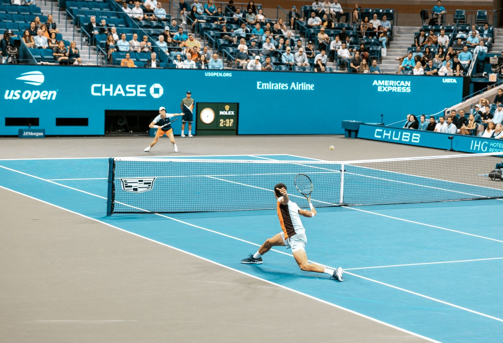 Players in action during a match on a bright tennis court