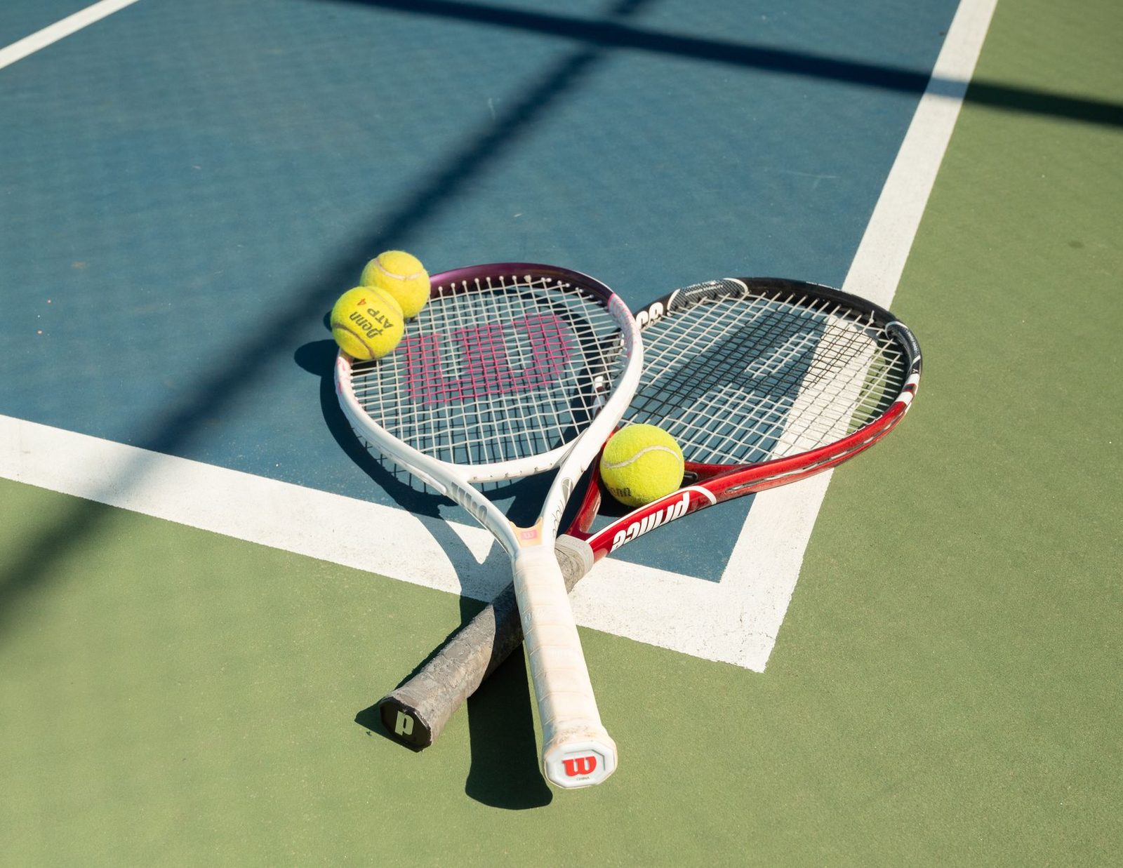 Tennis racquets and balls on a sunny outdoor court