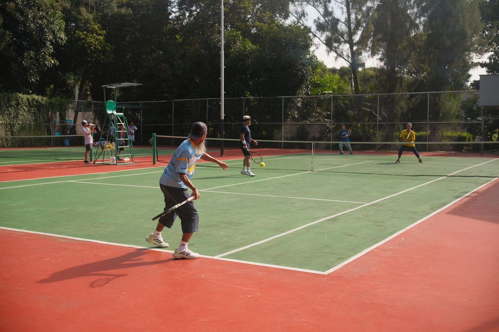 Tennis players competing on an outdoor court on a sunny day