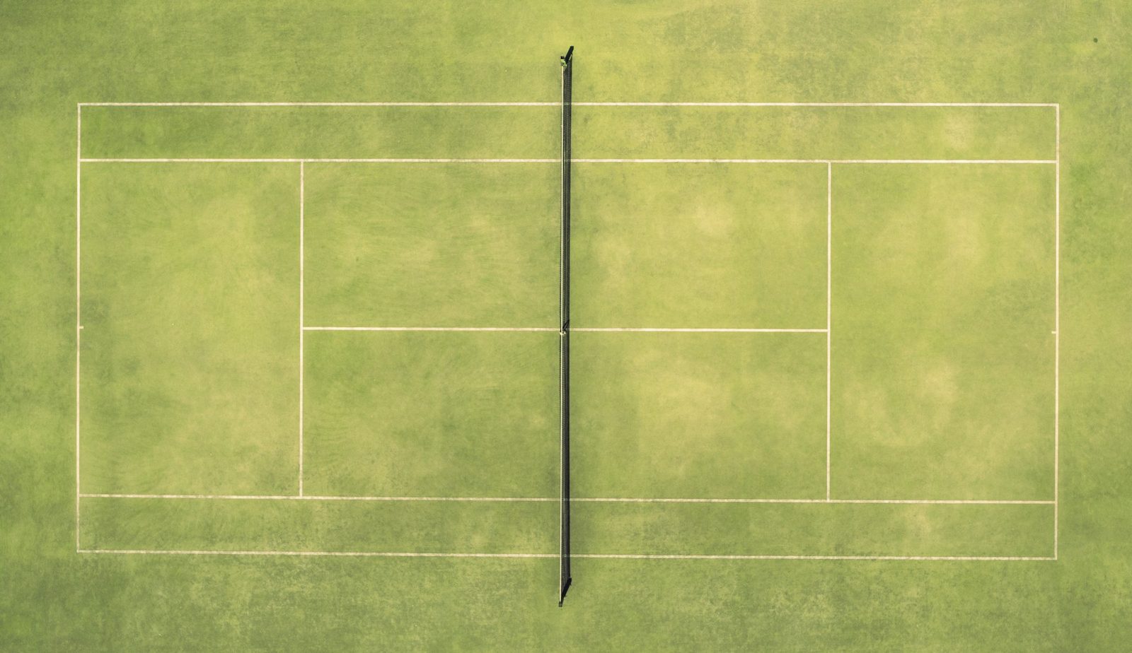 Overhead view of a tennis court with a ball and racquet