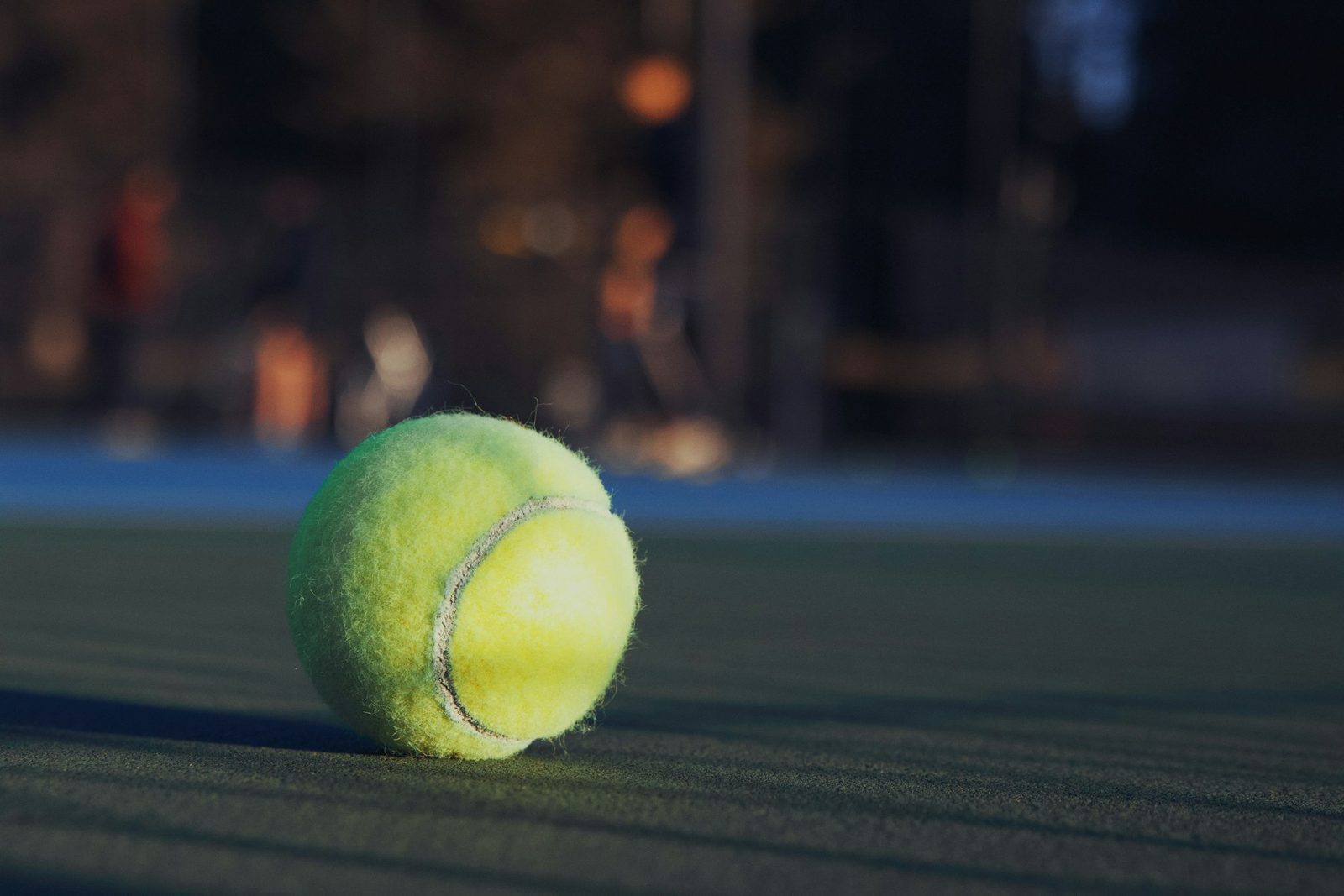 A tennis ball sitting on a tennis court