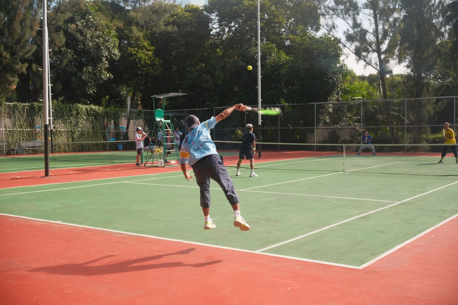 A tennis match on an outdoor court with players in motion
