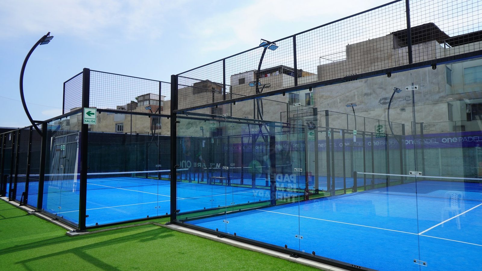 Enclosed court surrounded by fencing and glass panels