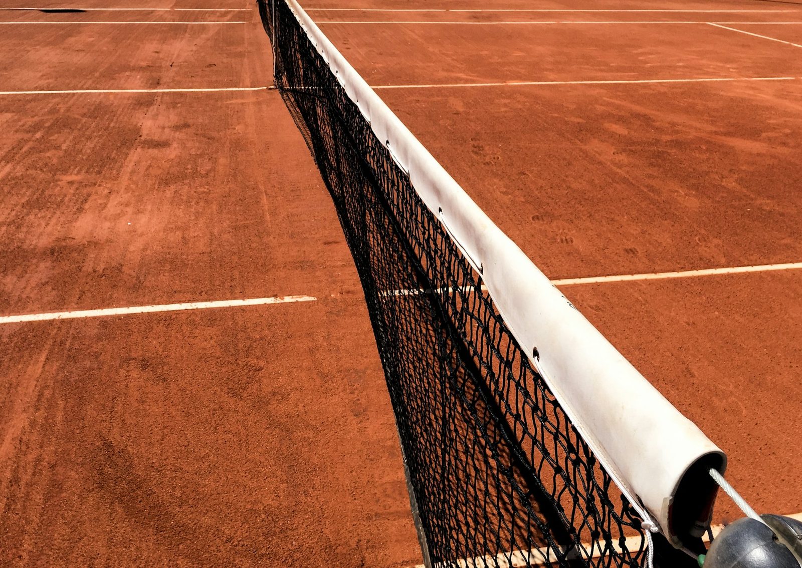 Black and white view of a tennis net seen across the court