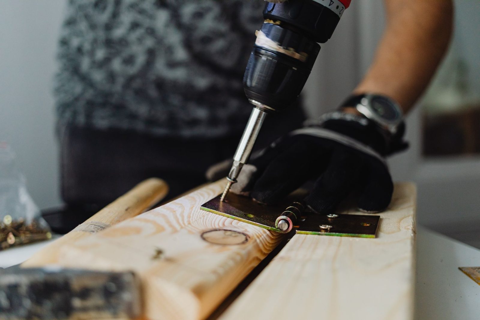 Close view of a drill being used to fix a wooden plank