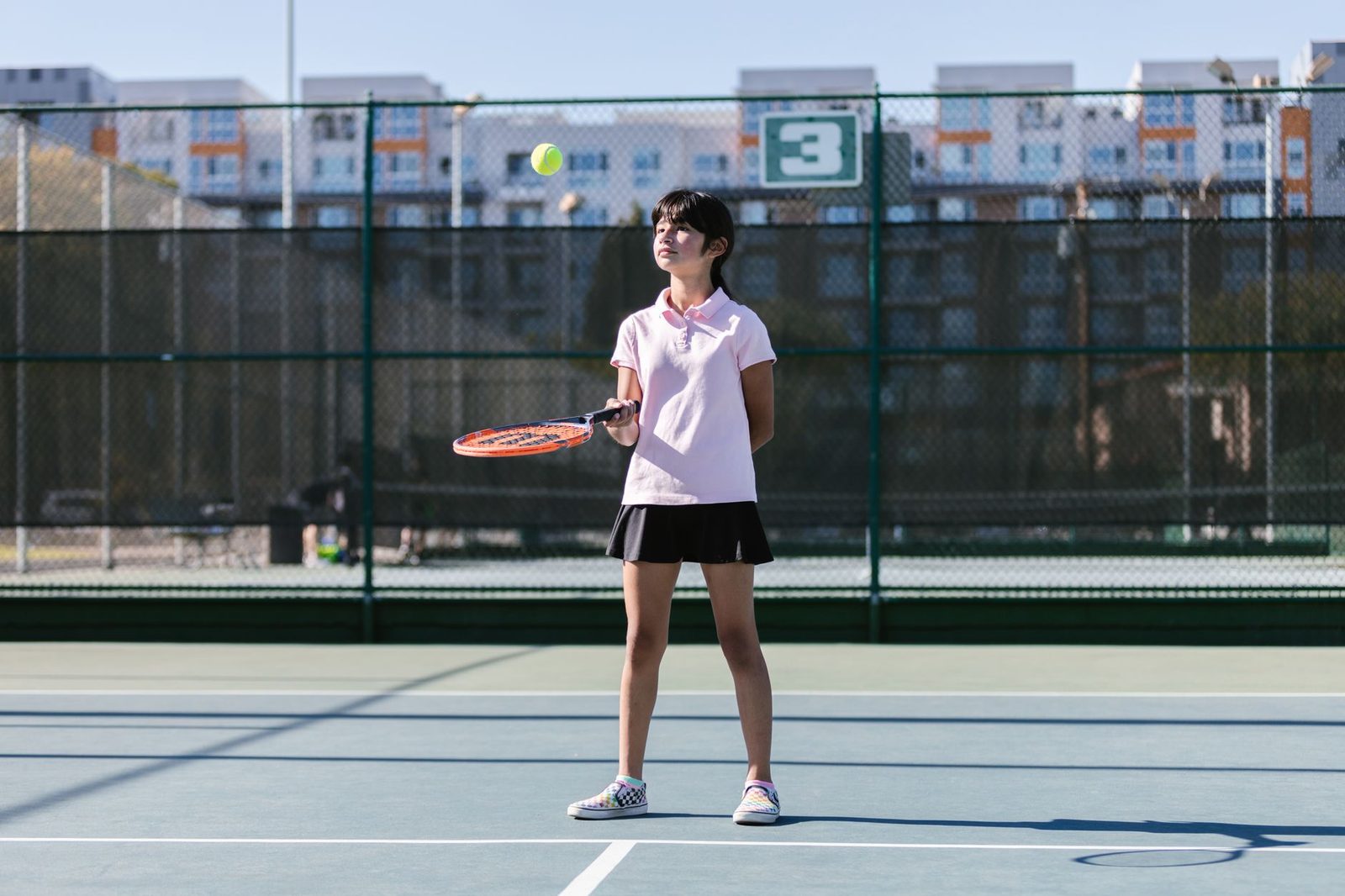 Player practising serves on a sunny outdoor court
