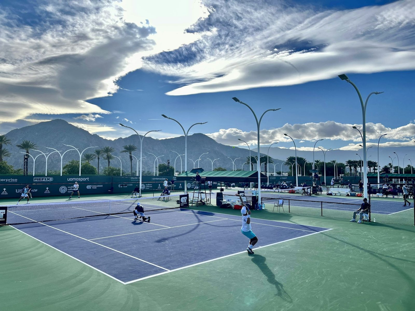 Group of people playing tennis together on a public court