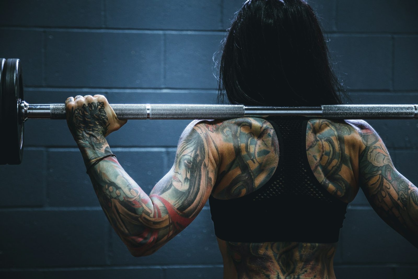 A woman carrying a barbell during strength training