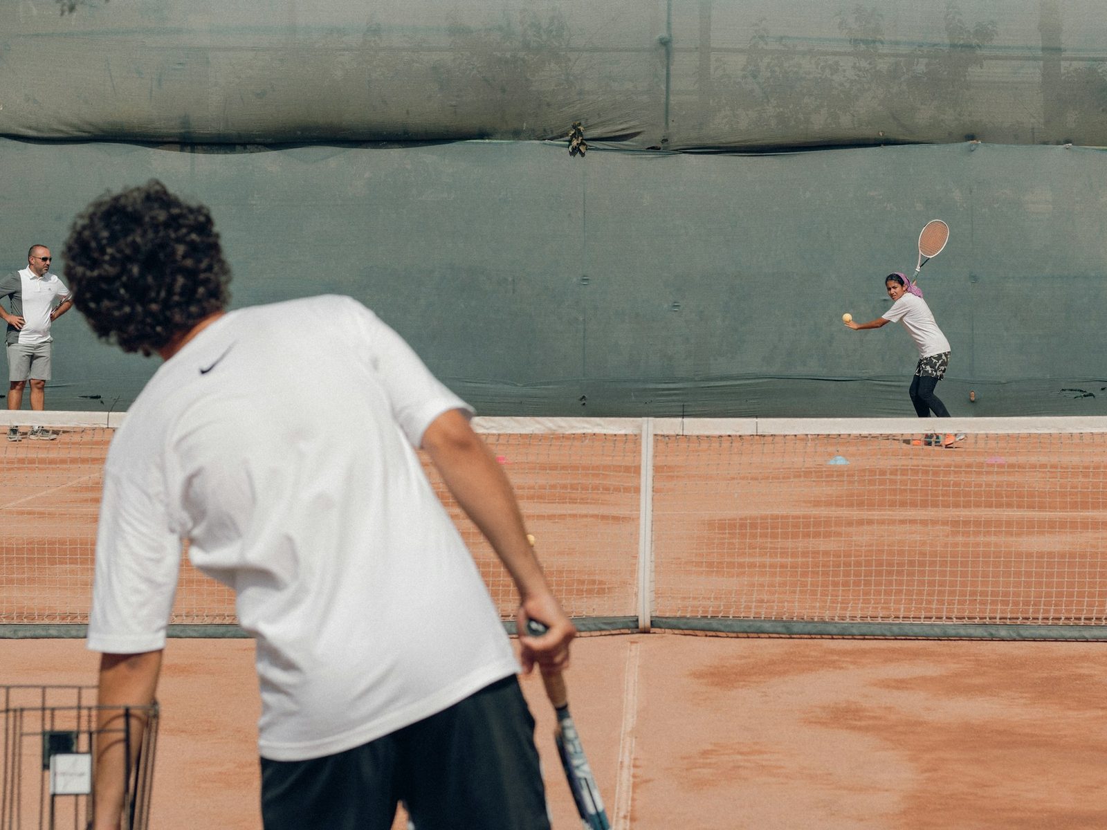 Player striking a ball with a racquet during a practice session