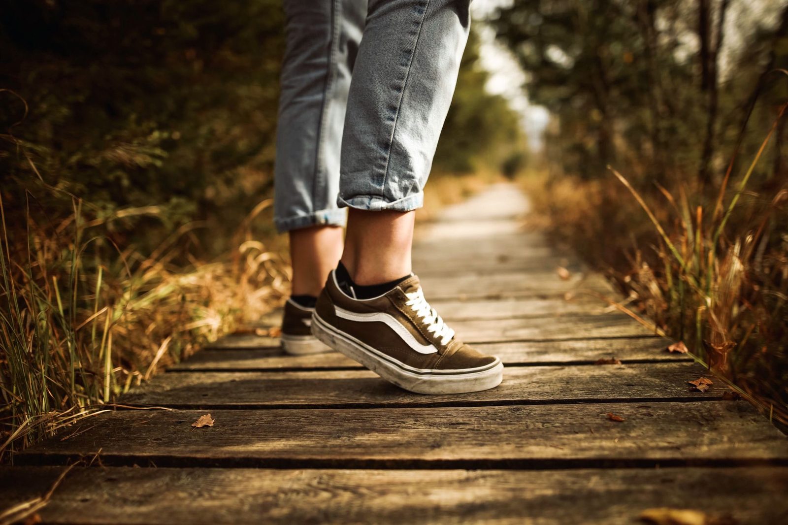 Close view of a person walking along a wooden path in a park